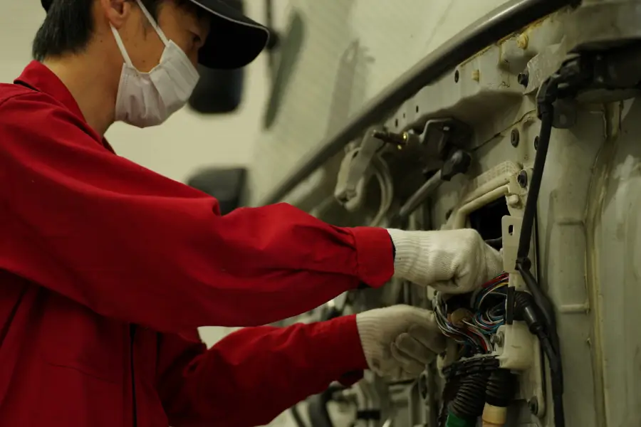 写真：車両を電装品の修理している作業員